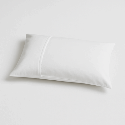 White pillow with envelope-style closure on a smooth surface, showcasing a clean, minimalist design ideal for hospitality or home use.